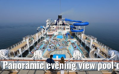Panoramic evening view pool deck and waterslides with peoples Norwegian Bliss